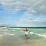 Rainbow from the sea into the white sand beach at Tulum